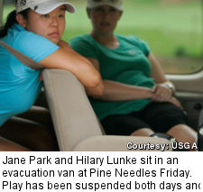 Jane Park and Hilary Lunke sit in an evacuation van at Pine Needles Friday. Play has been suspended both days and more rain is expected tomorrow.